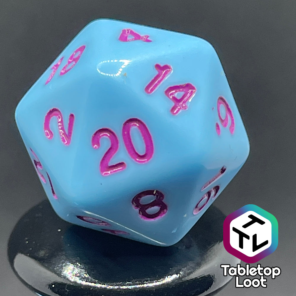 A close up of the D20 from the Bantha Milk 7 piece dice set from Tabletop Loot with purple numbering on solid pastel blue faces.