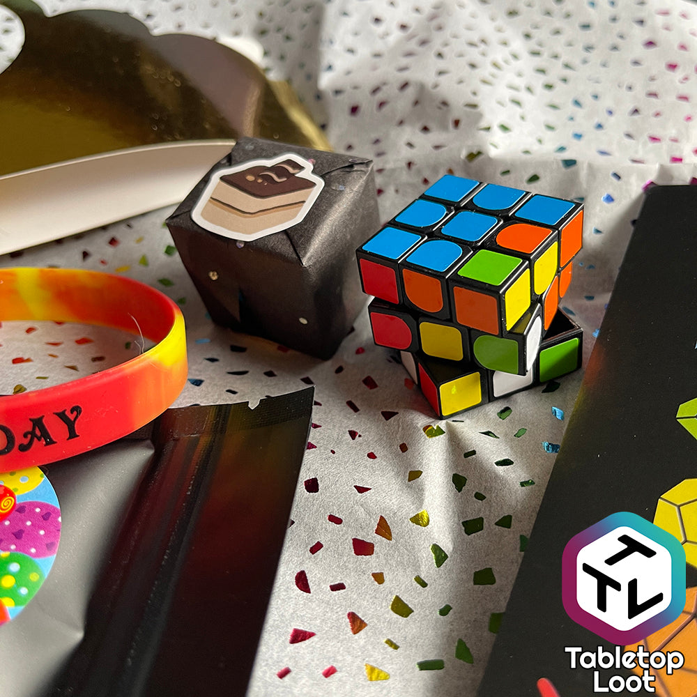 A small wrapped square sits next to a puzzle cube.