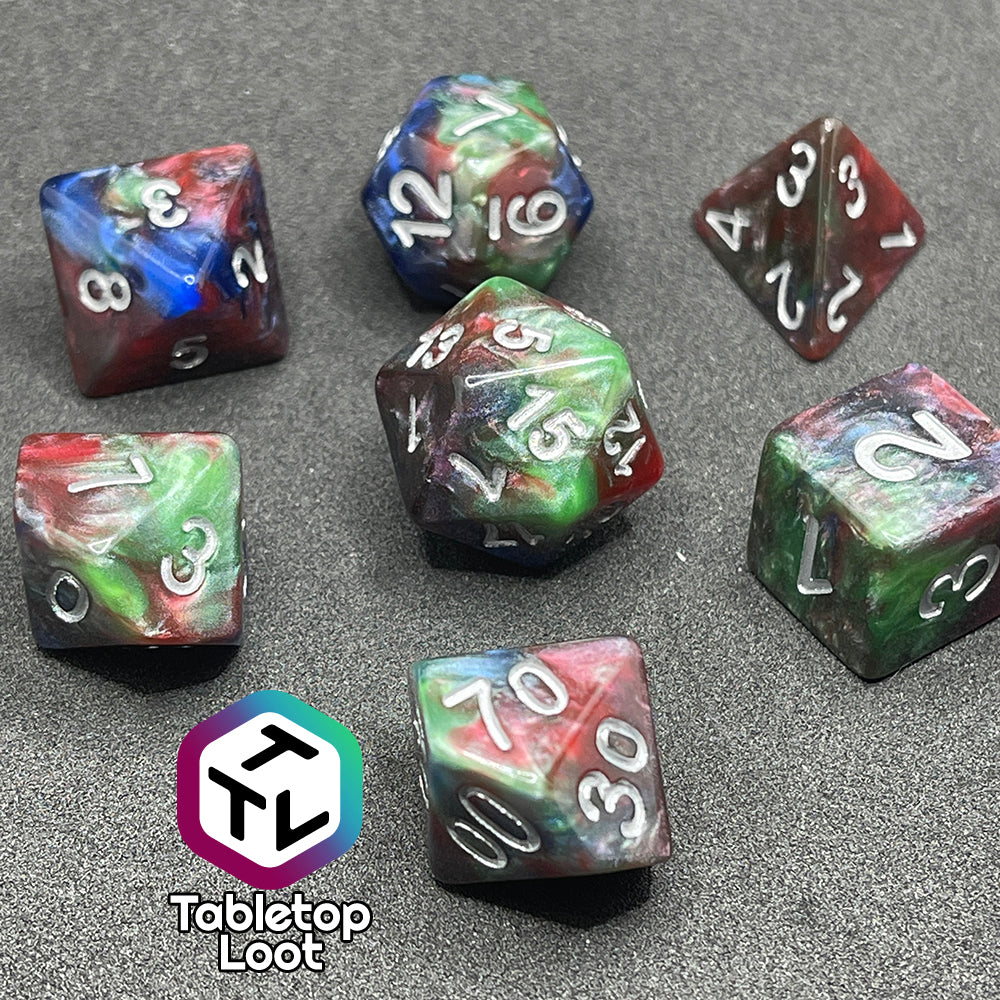 The Changeling 7 piece dice set from Tabletop Loot with swirls of pearlescent red, green, and blue and silver numbering.