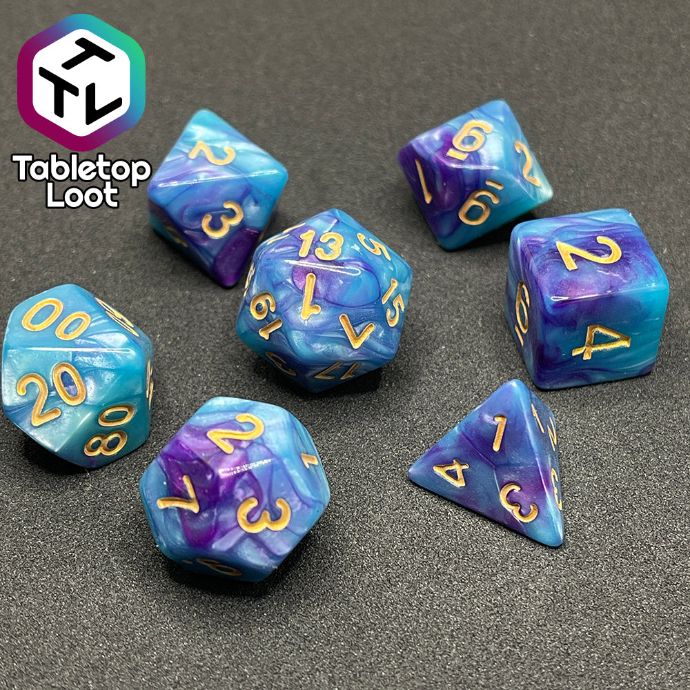 The Cotton Candy 7 piece dice set from Tabletop Loot with swirls of blue and purple and golden numbers.