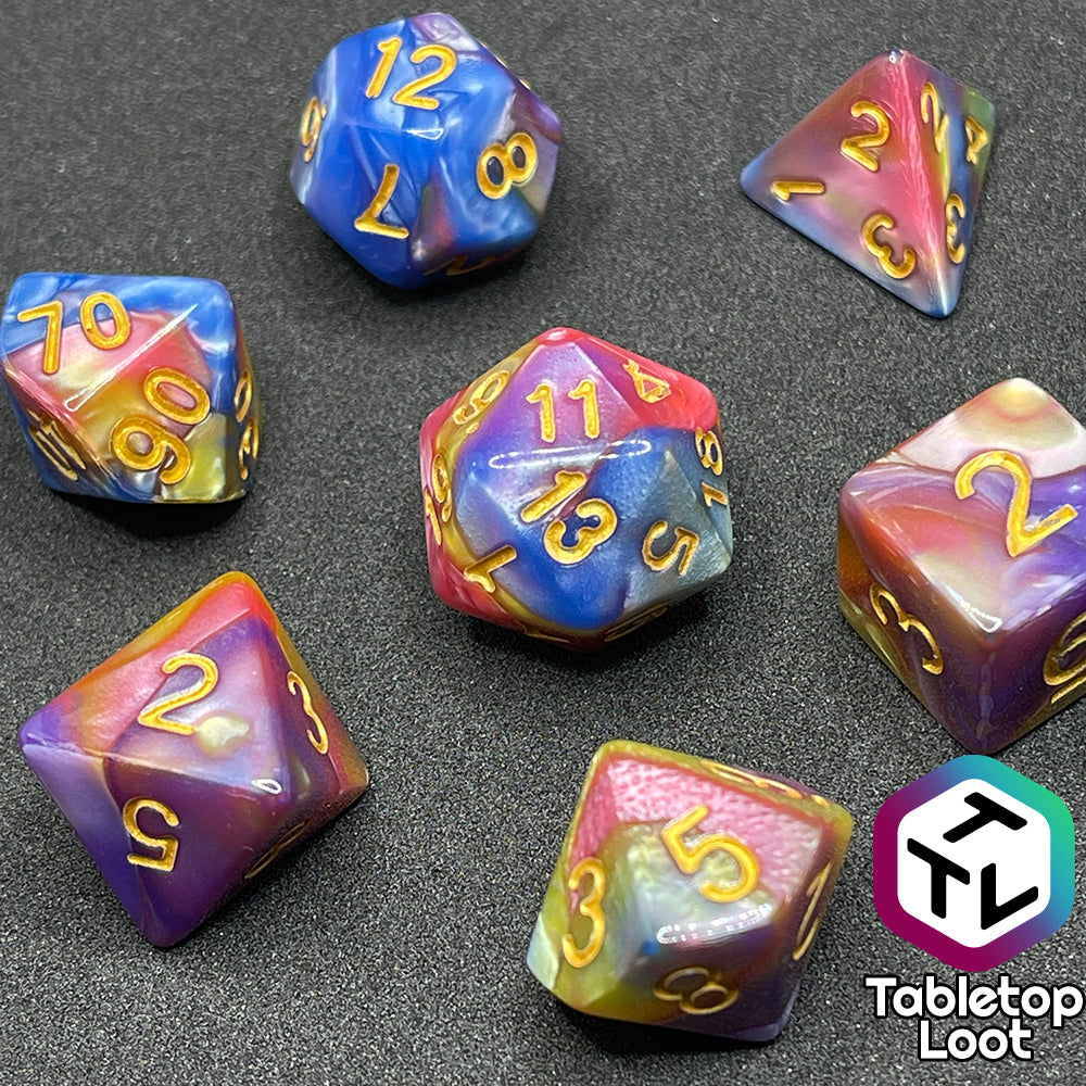 The Fey and Flowers 7 piece dice set with swirls of pearlescent shades of yellow, purple, red, blue, and green and gold numbering.