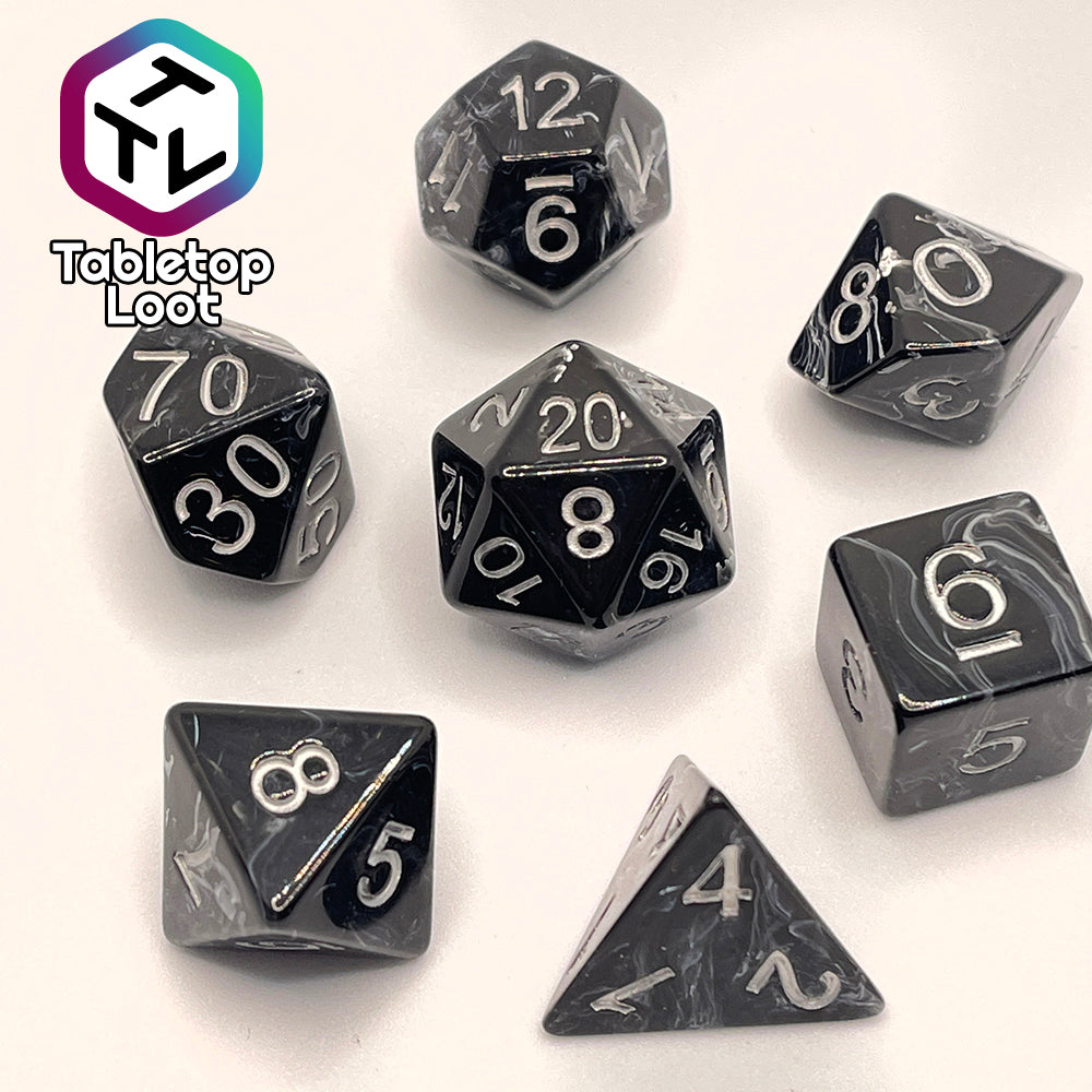The Form of Dread 7 piece dice set from Tabletop Loot with swirls of white in black resin and silver numbering.