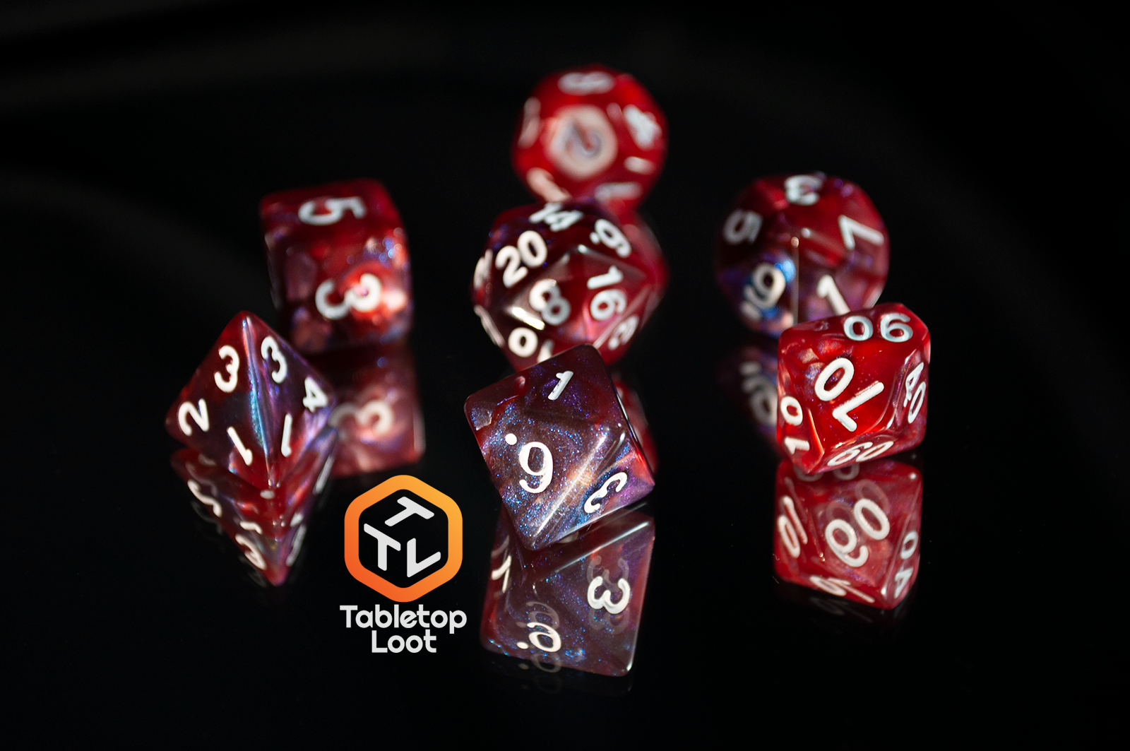 The Lava Galaxy 7 piece dice set from Tabletop Loot with swirls of red, blue, and purple with tons of shimmer and white numbers.