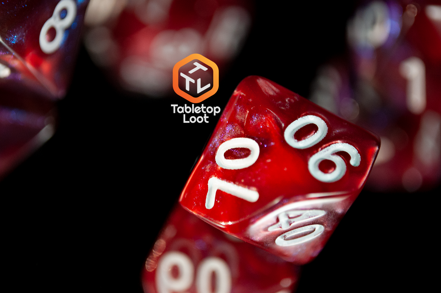 A close up of the percentile die from the Lava Galaxy 7 piece dice set from Tabletop Loot with swirls of red, blue, and purple with tons of shimmer and white numbers.