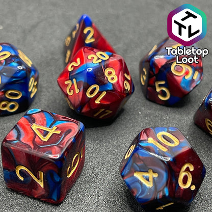 A close up of the Metropolis 7 piece dice set with swirls of pearlescent blue and red and gold numbering.