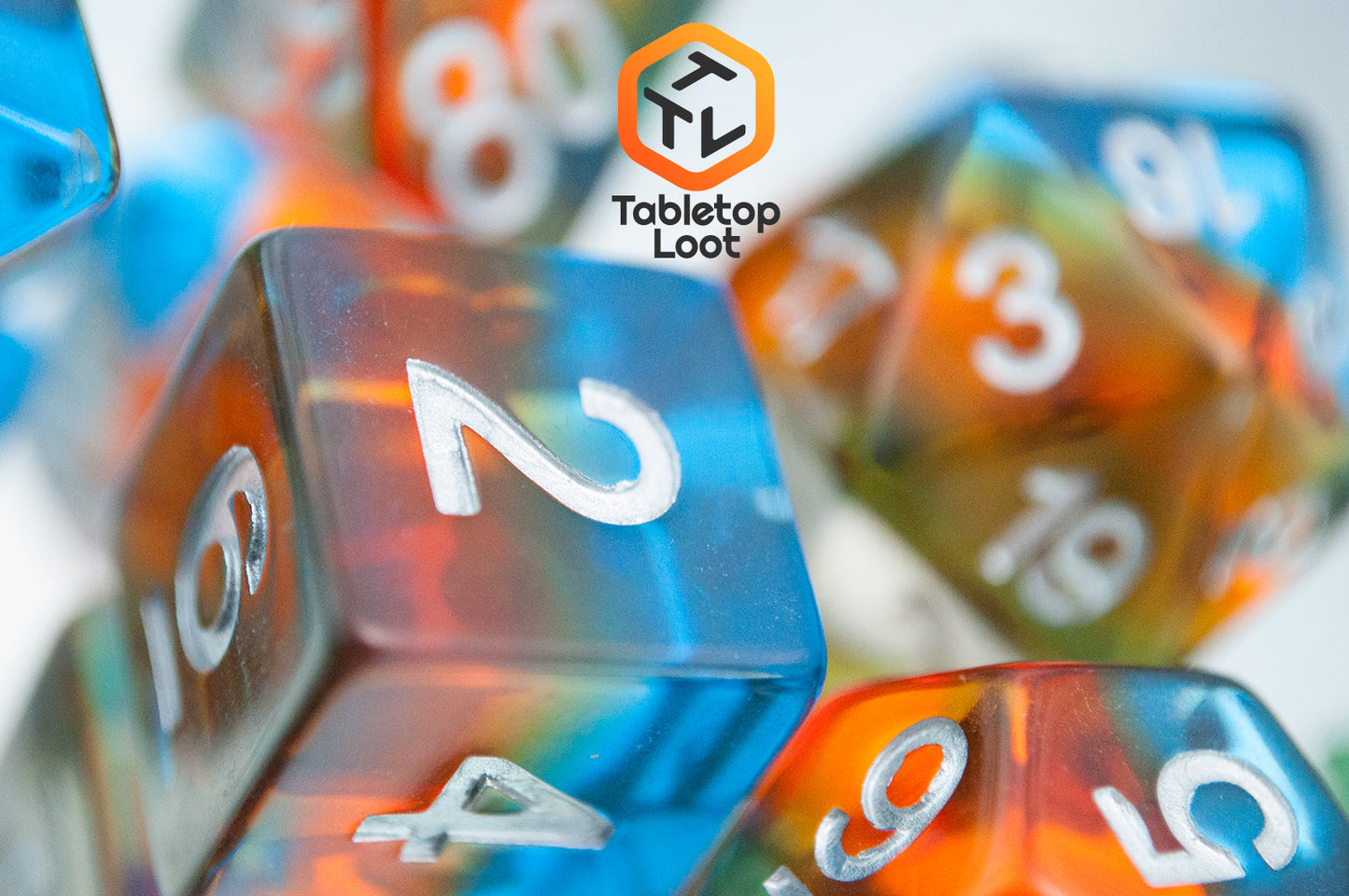 A close up of the D6 from the Parallel Universes 7 piece dice set from Tabletop Loot with an orange stripe in blue resin and silver numbering.