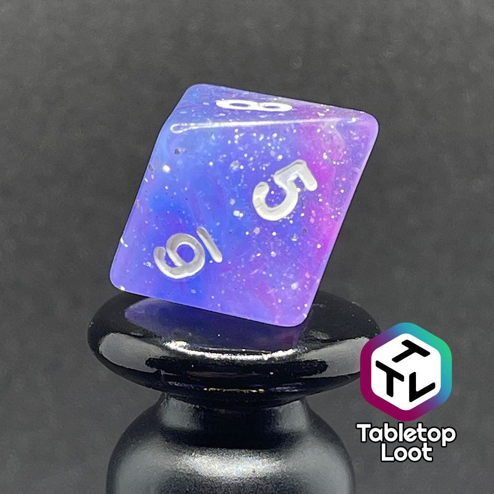 A close up of the D8 from the Phantasmal Force 7 piece dice set with swirls of blue and purple, lots of glitter, and white numbering.