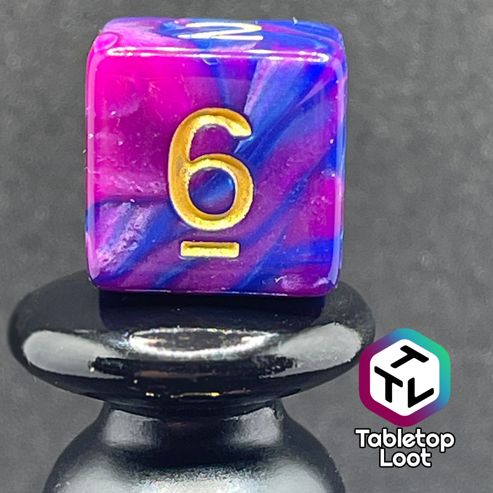 A close up of the D6 from the Spelljammin' 7 piece dice set from Tabletop Loot with pearlescent swirls of purple and blue and gold numbering.