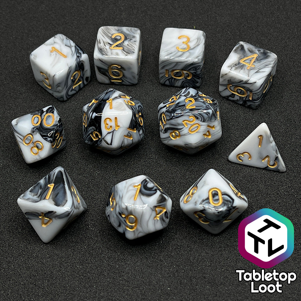 The Rolling Thunder 11 piece dice set from Tabletop Loot, black and white marbled patterns and gold numbering.