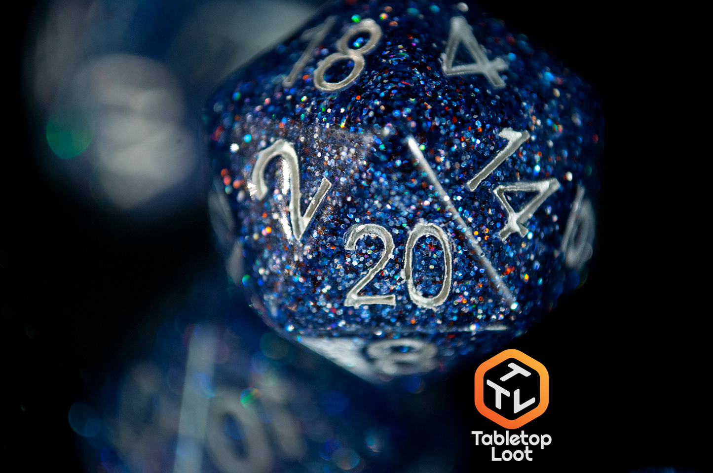 A close up of the D10 from the Starry Form 7 piece dice set from Tabletop Loot packed with blue glitter and silver numbering.
