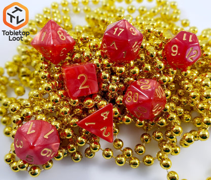 The Atomic Cinnamon 7 piece dice set from Tabletop Loot with swirls of red resin and gold numbering.