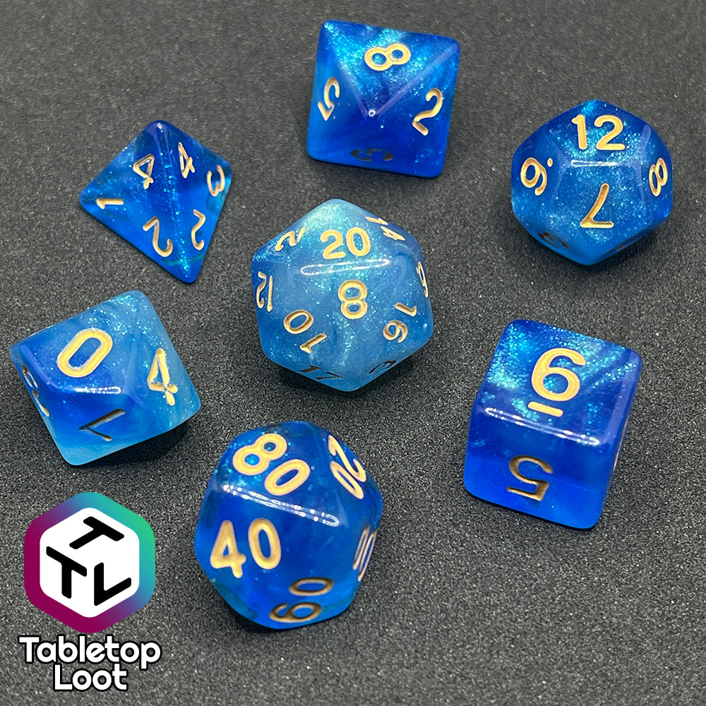 The Air Genasi 7 piece dice set from Tabletop Loot with swirls of glittering tones of blue and gold numbers.