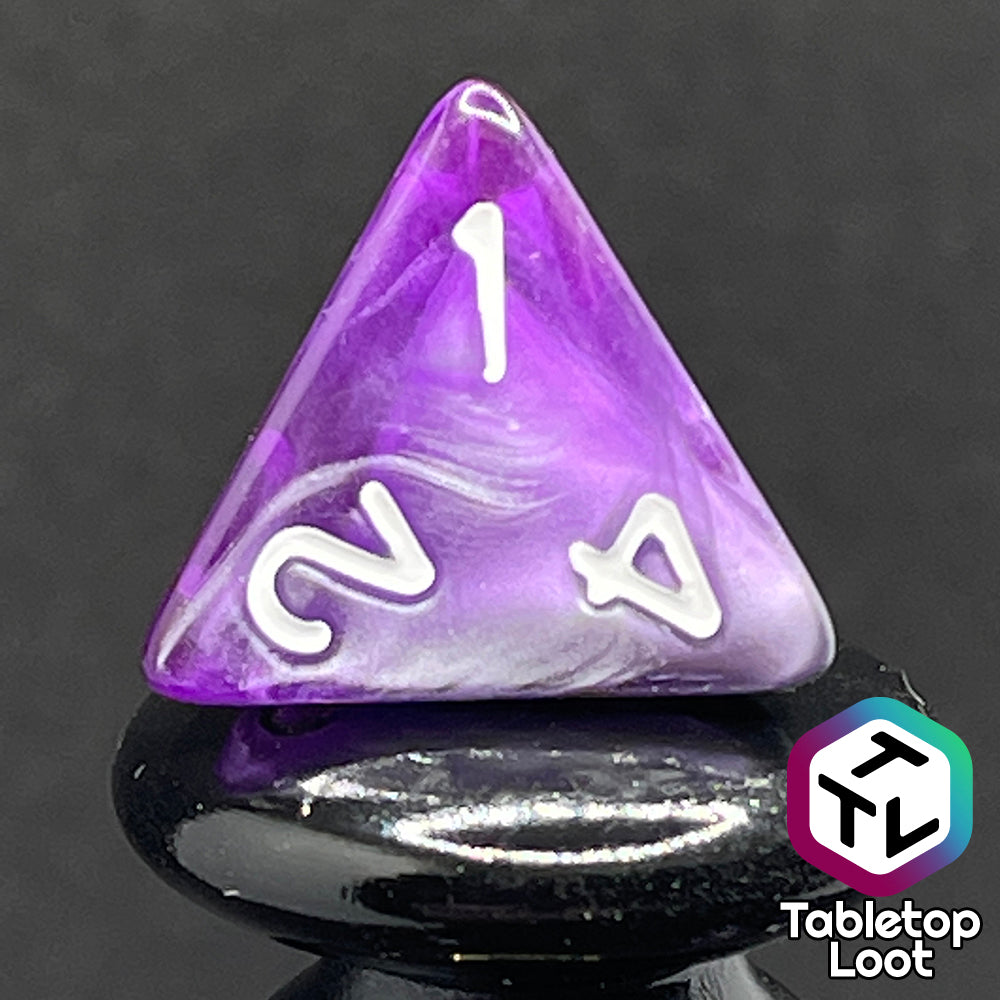 A close up of the D4 from the Amethyst Dreams 7 piece dice set with swirls of purple and silver and white numbering.