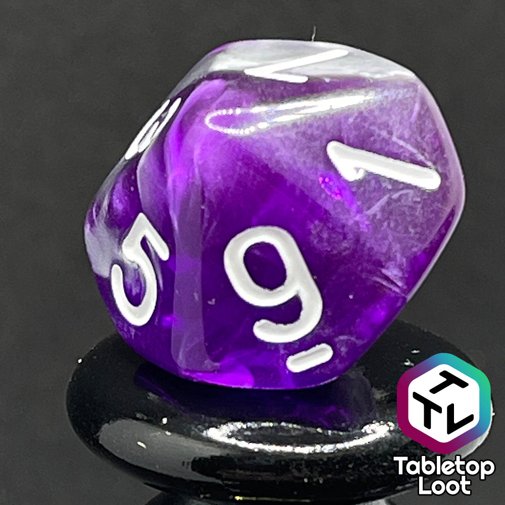 A close up of the D10 from the Amethyst Dreams 7 piece dice set with swirls of purple and silver and white numbering.