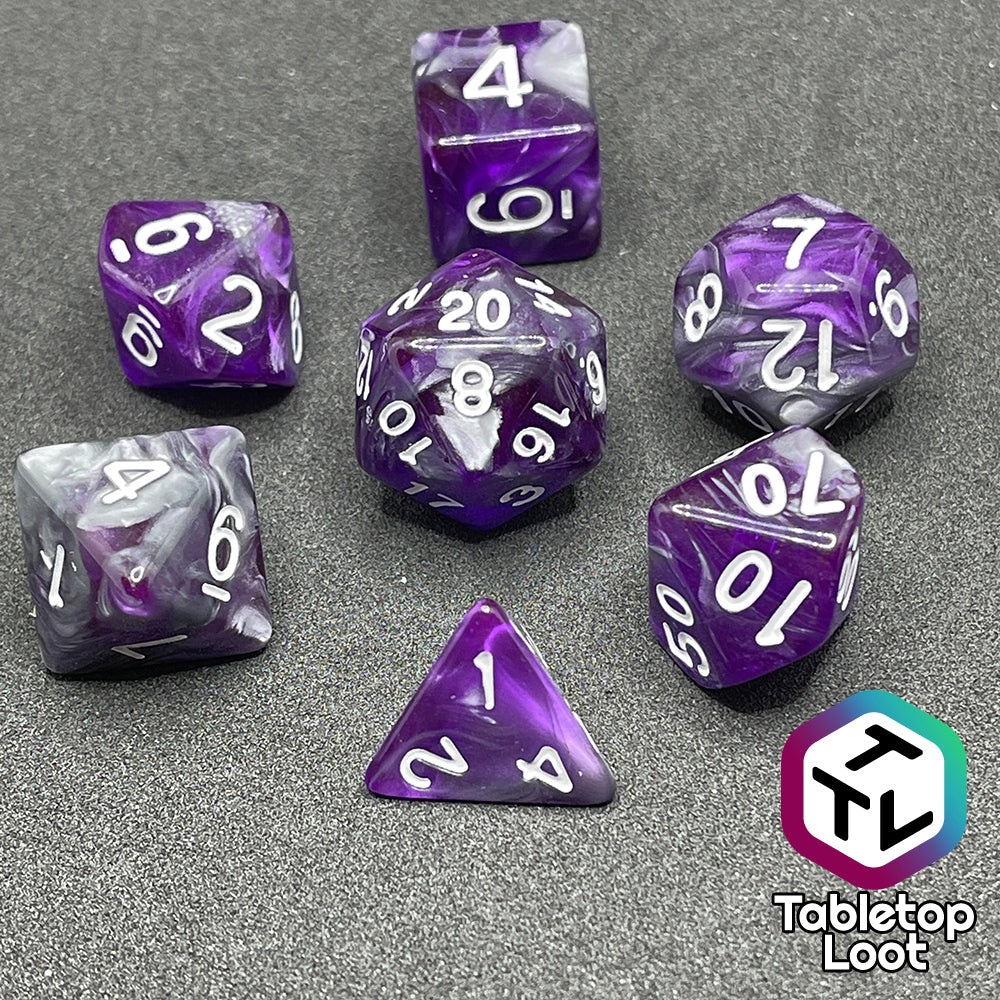 The Amethyst Dreams 7 piece dice set with swirls of purple and silver and white numbering.