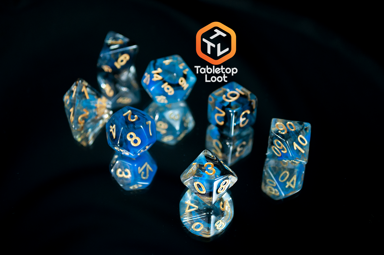 The Arcane Eye 7 piece dice set from Tabletop Loot with swirls of blue and black in clear dice and gold numbering.