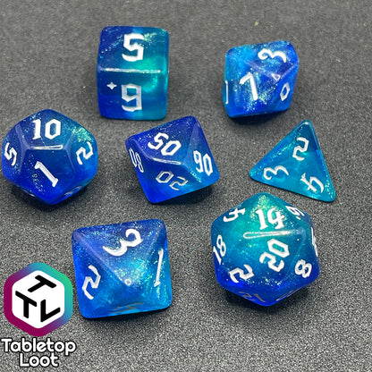 The Armor of Agathys 7 piece dice set from Tabletop Loot with shimmering tones of blue swirling together and white numbering in a gothic font.