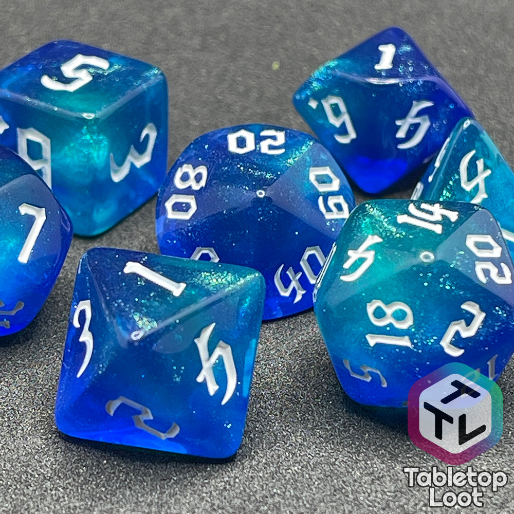 A close up of the Armor of Agathys 7 piece dice set from Tabletop Loot with shimmering tones of blue swirling together and white numbering in a gothic font.