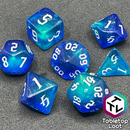 The Armor of Agathys 7 piece dice set from Tabletop Loot with shimmering tones of blue swirling together and white numbering in a gothic font.