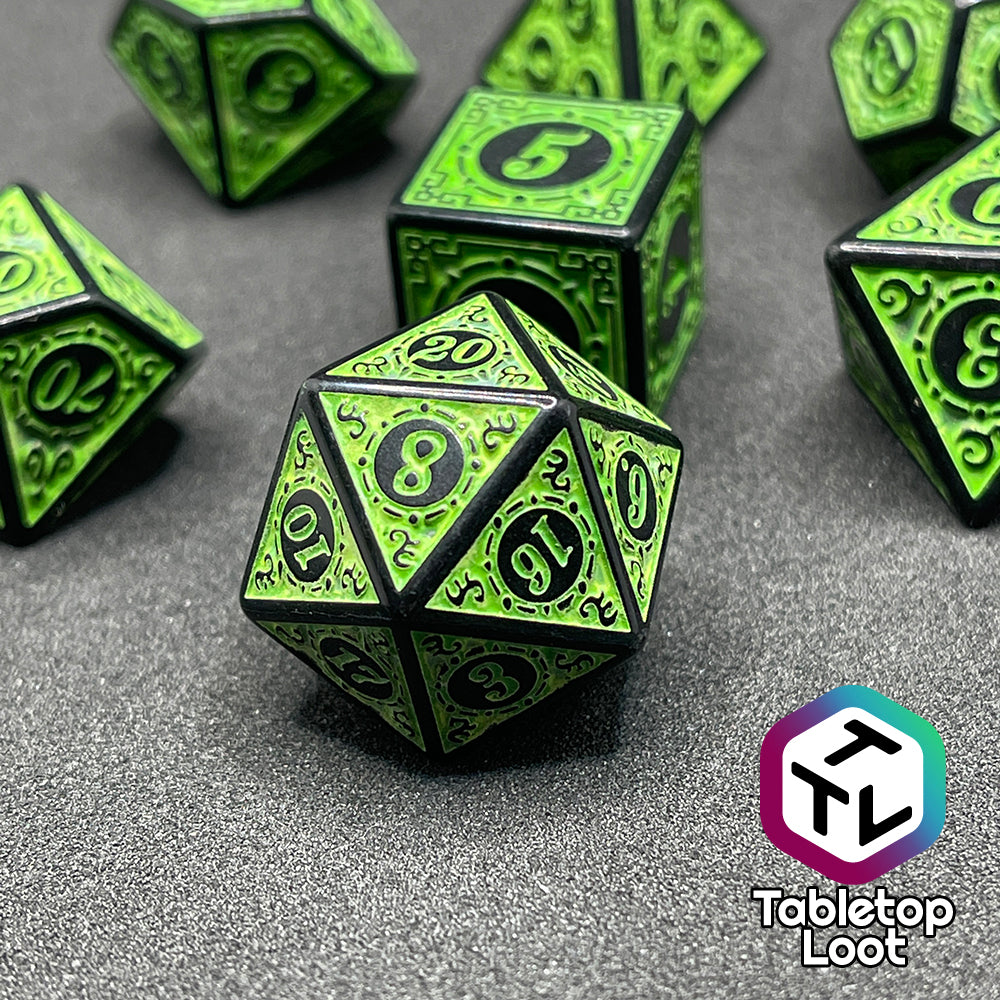 A close up of the Artificer's Delight 7 piece dice set from Tabletop Loot with bold, neon green numbers on intricate scrolling black frames that make up each side.