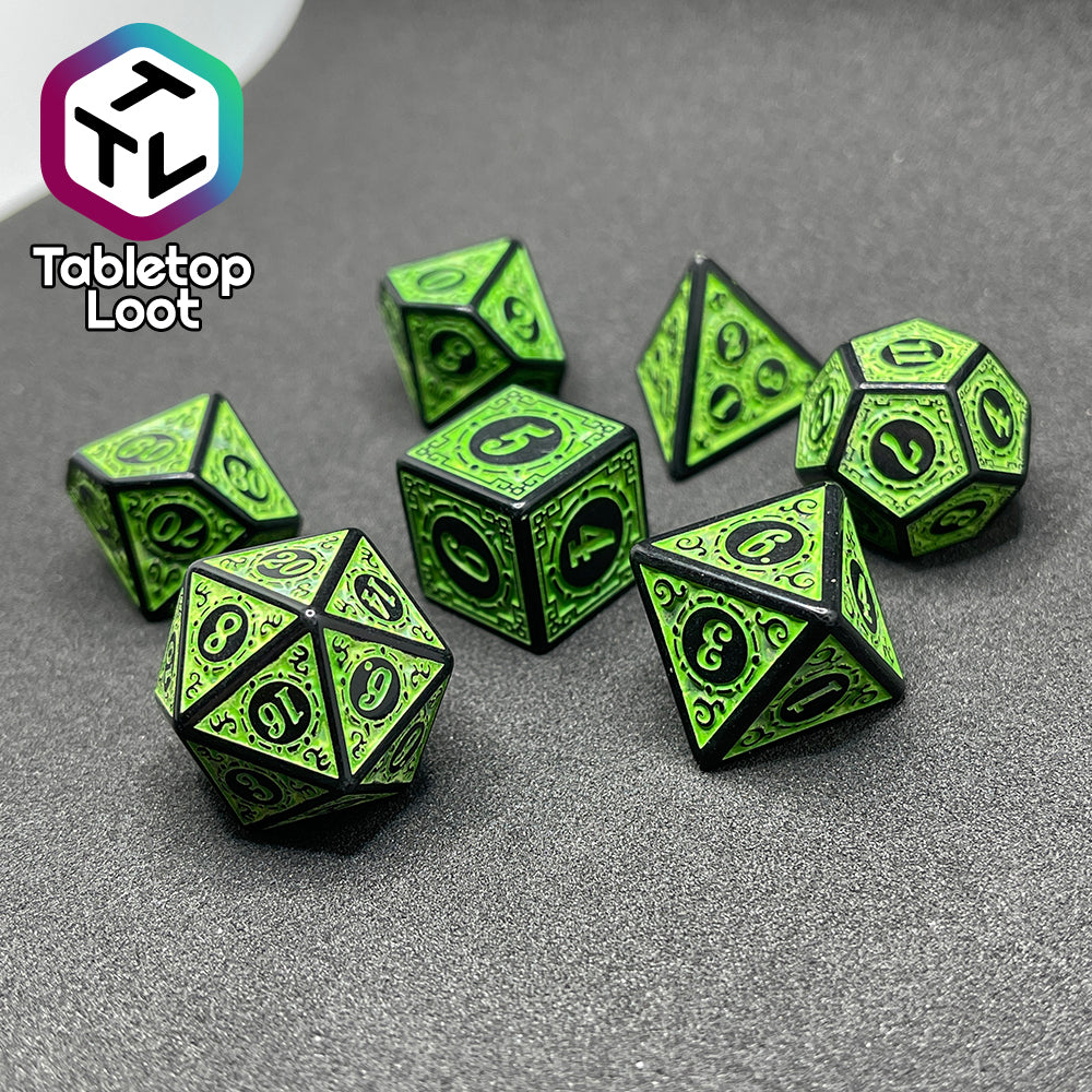 The Artificer's Delight 7 piece dice set from Tabletop Loot with bold, neon green numbers on intricate scrolling black frames that make up each side.