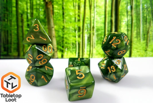 The Bamboo Forest 7 piece dice set from Tabletop Loot with swirls of pearlescent green resin and gold numbering.