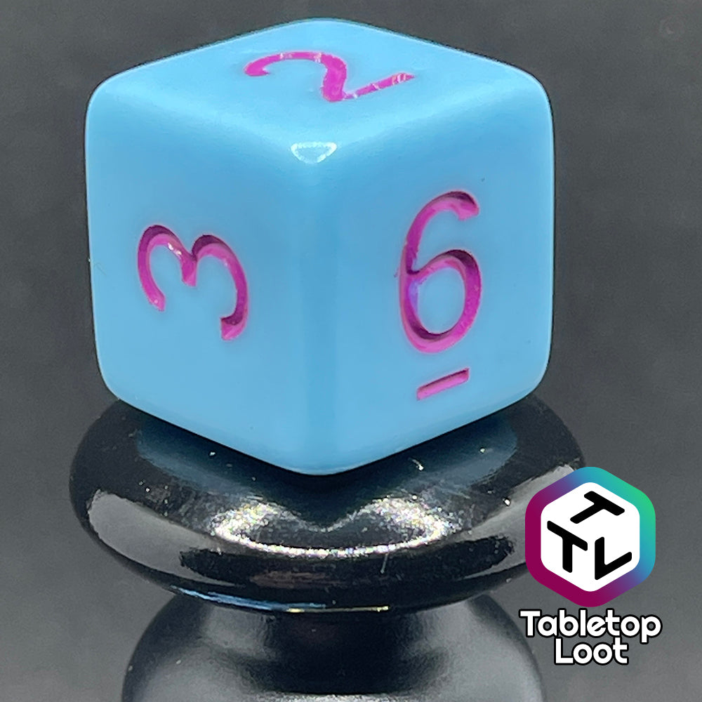 A close up of the D6 from the Bantha Milk 7 piece dice set from Tabletop Loot with purple numbering on solid pastel blue faces.