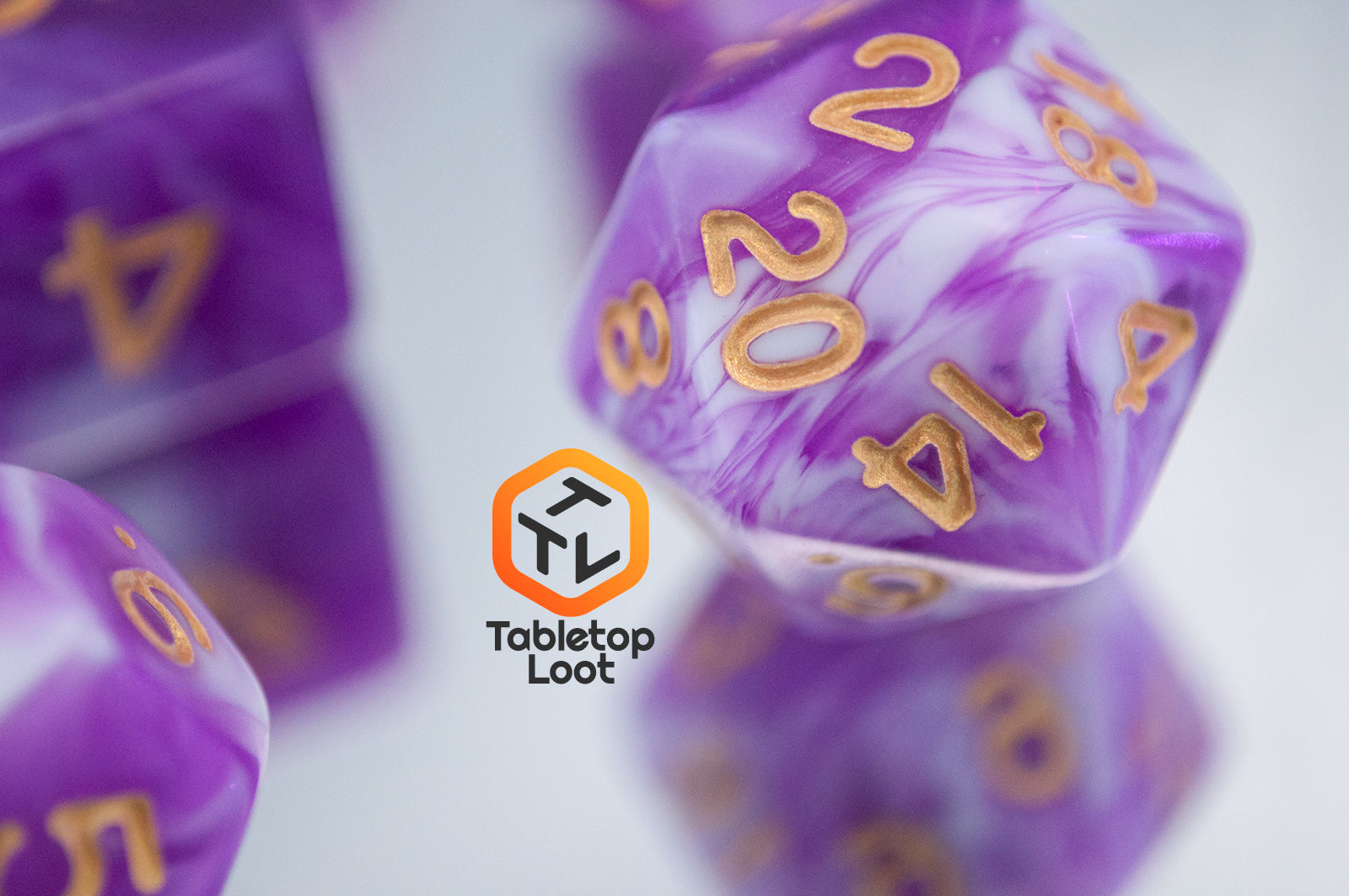 A close up of the D20 from the Berry Blast 7 piece dice set from Tabletop Loot with swirls of purple and white and gold numbering.
