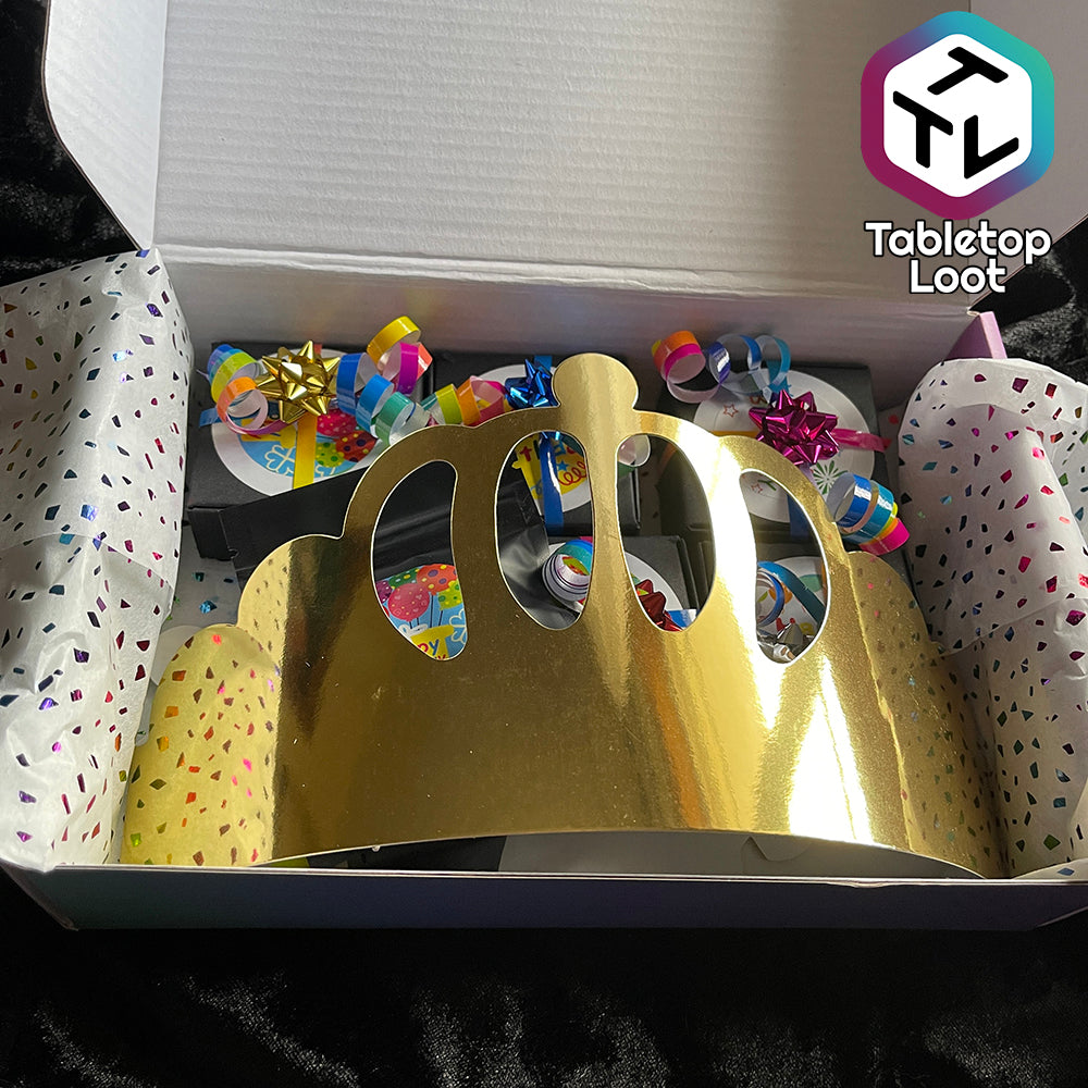 A loot box showing several small boxes wrapped in colorful ribbon covered by a gold foil paper crown.