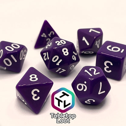 A close up of the Blackberries 7 piece dice set; solid purple with white numbering.