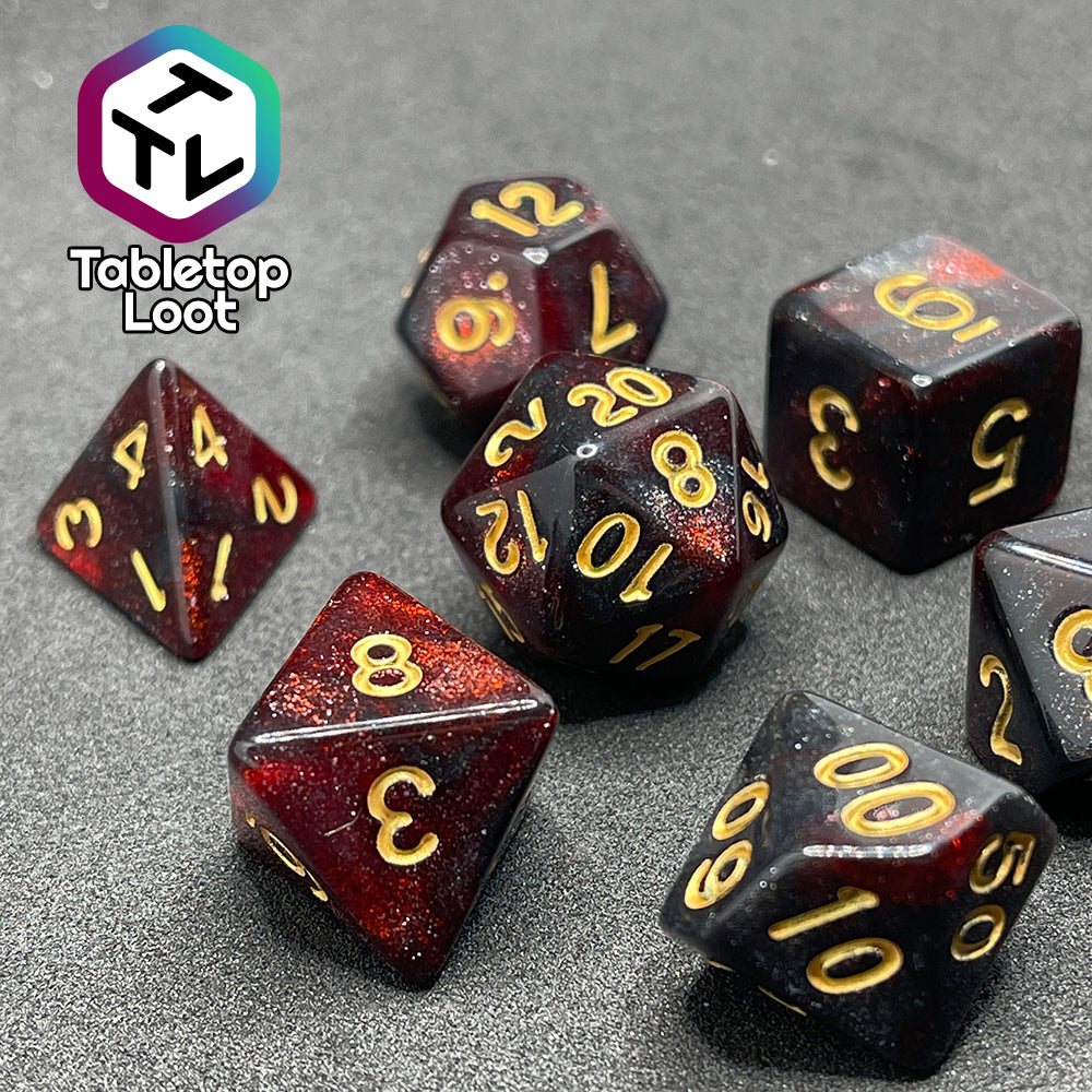 A close up of the Blood Lust 7 piece dice set from Tabletop Loot with swirls of dark glittery red which looks almost black and gold numbering.