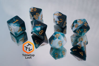 The Blue Ink 7 piece dice set from Tabletop Loot with swirls of ocean blue and white resin and gold numbering.