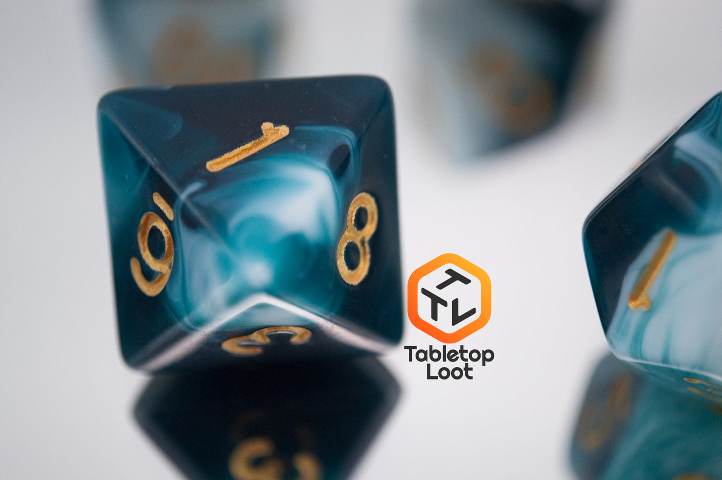 A close up of the D8 from the Blue Ink 7 piece dice set from Tabletop Loot with swirls of ocean blue and white resin and gold numbering.
