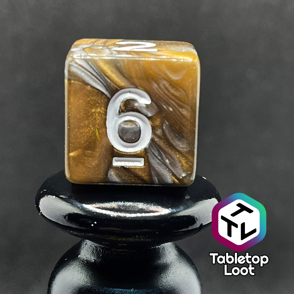 A close up of the D6 from the Bronze Dragon 7 piece dice set from Tabletop Loot with swirls of pearlescent bronze and silver and silver numbering.