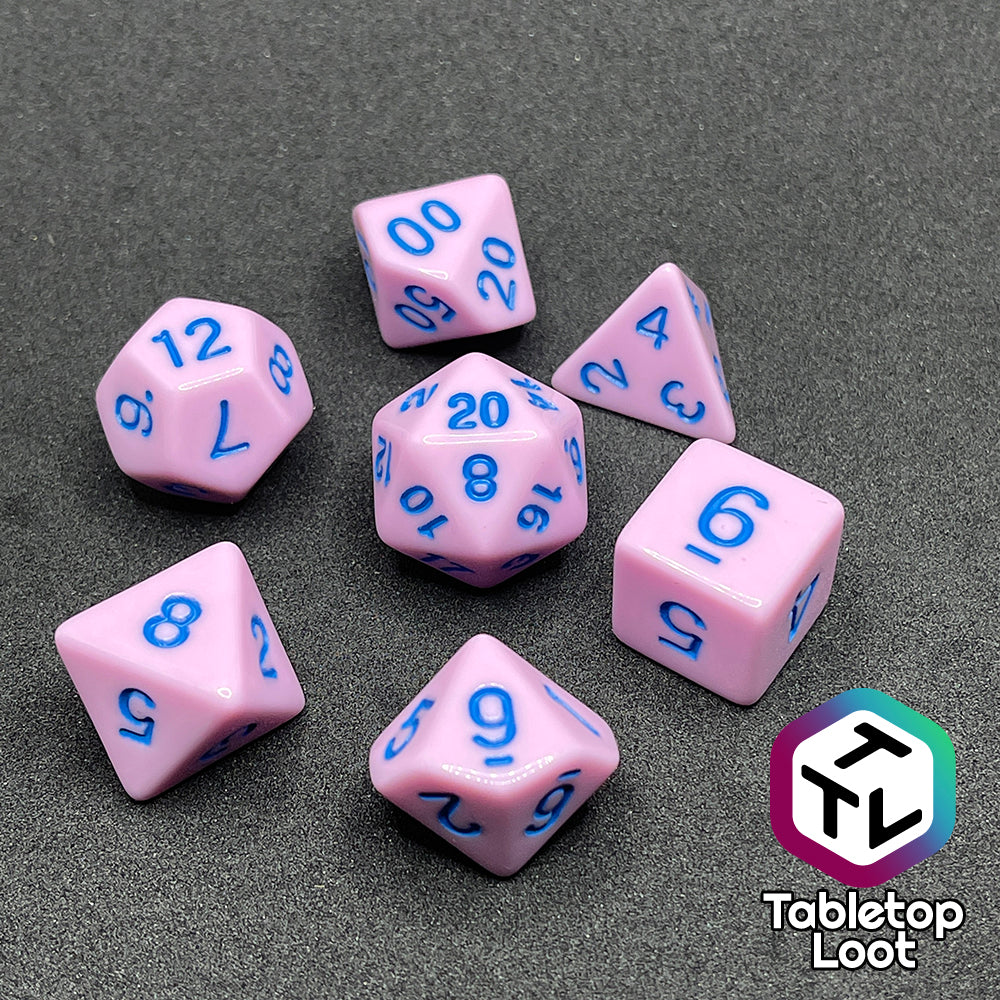 The Berry Bubblegum 7 piece dice set from Tabletop Loot with blue numbering on solid pastel pink sides.