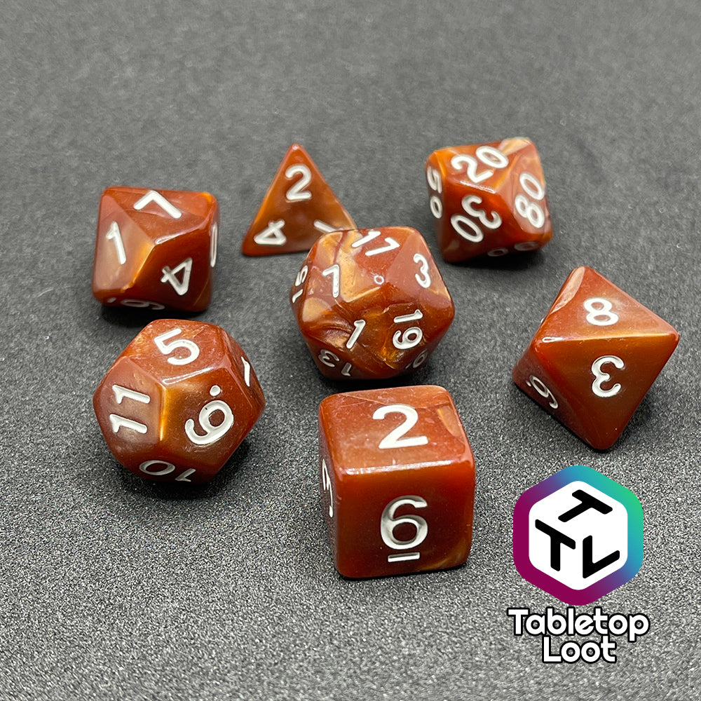The Caramels 7 piece dice set from Tabletop Loot with pearlescent swirls of caramel brown color and white numbering.
