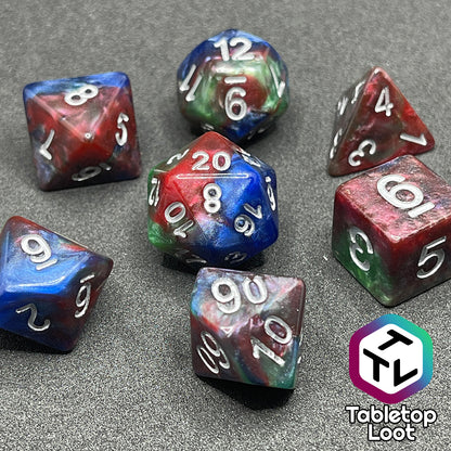 The Changeling 7 piece dice set from Tabletop Loot with swirls of pearlescent red, green, and blue and silver numbering.