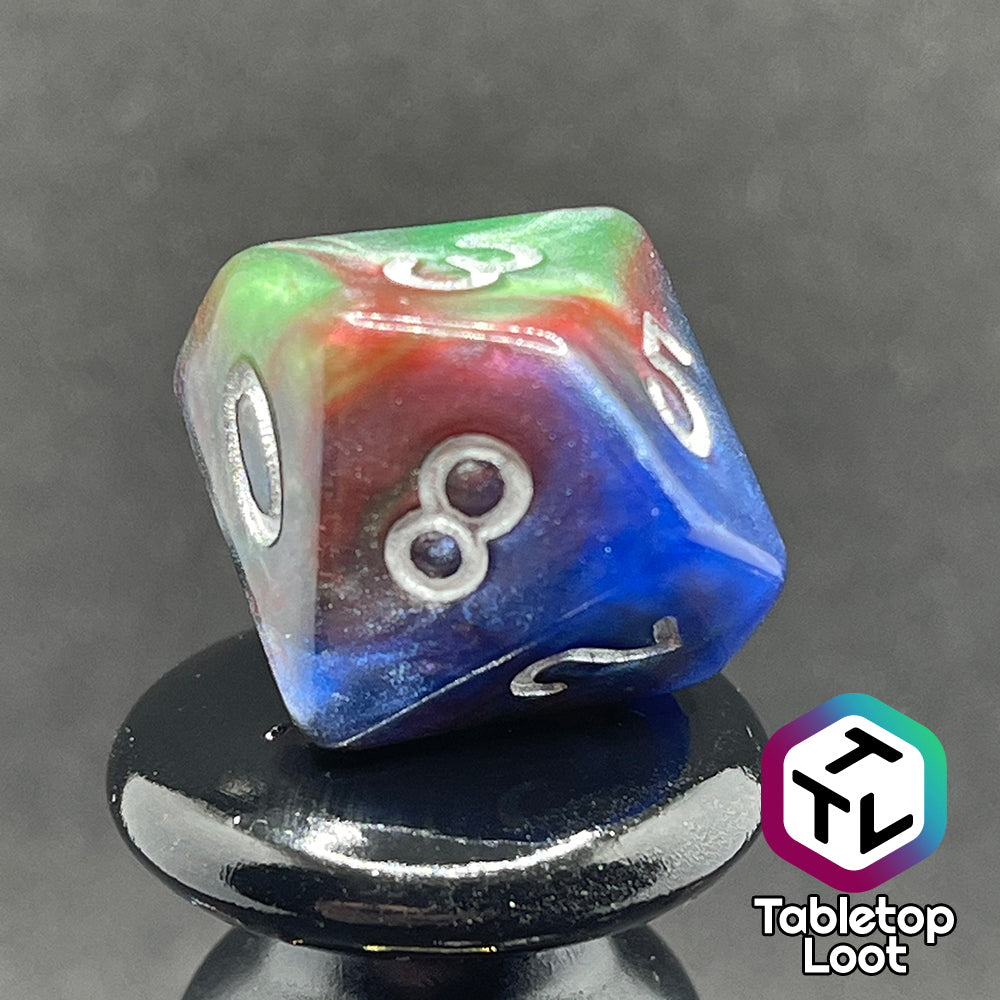 A close up of the D10 from the Changeling 7 piece dice set from Tabletop Loot with swirls of pearlescent red, green, and blue and silver numbering.