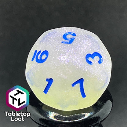 A close up of the D10 from the Clairvoyance 7 piece dice set from Tabletop Loot with royal blue numbering on milky shimmery dice.