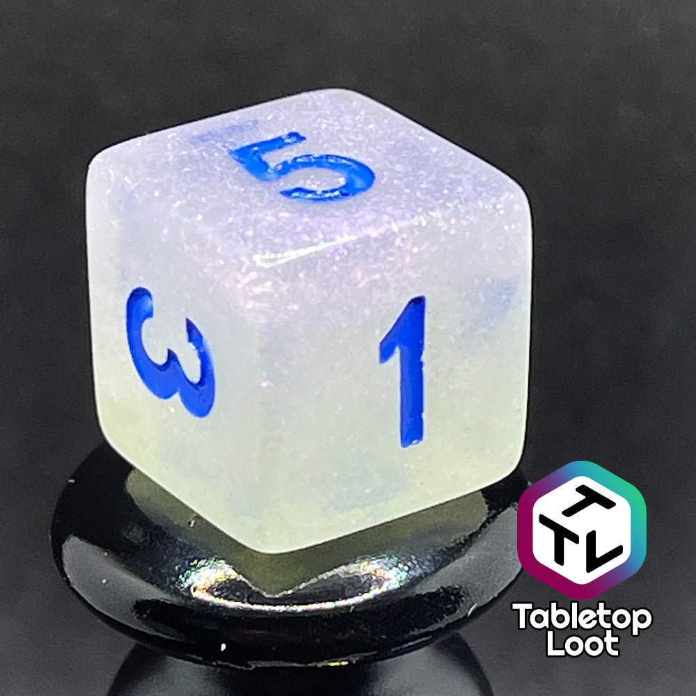 A close up of the D6 from the Clairvoyance 7 piece dice set from Tabletop Loot with royal blue numbering on milky shimmery dice.