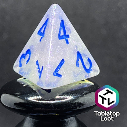 A close up of the D4 from the Clairvoyance 7 piece dice set from Tabletop Loot with royal blue numbering on milky shimmery dice.