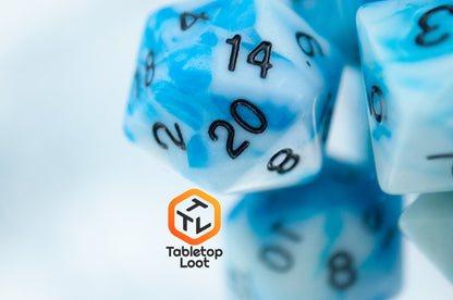 A close up of the D20 from the Cloudy Sky 7 piece dice set from Tabletop Loot with swirls of bright blue and white resin and black numbering.