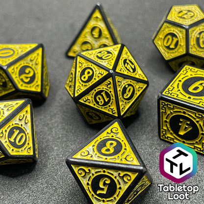 A close up of the Lament Configuration 7 piece dice set from Tabletop Loot with black borders, swirls, and stars and a bright yellow relief and numbering.