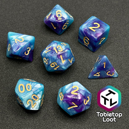 The Cotton Candy 7 piece dice set from Tabletop Loot with swirls of blue and purple and golden numbers.
