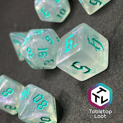 7 piece translucent polyhedral dice set with iridescent micro-glitter and red numbers.