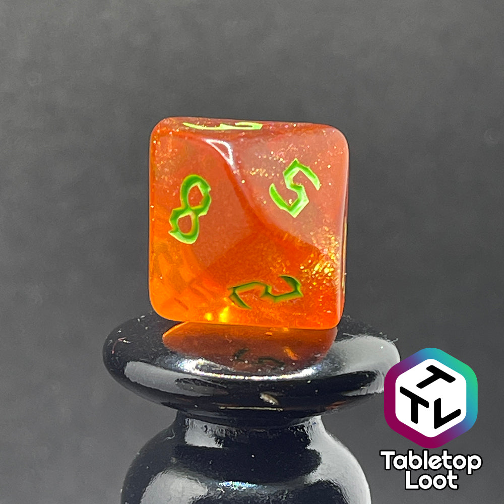 A close up of the D10 from the Cyber Punk'in 7 piece dice set from Tabletop Loot; glittery orange with neon green gothic numbering.