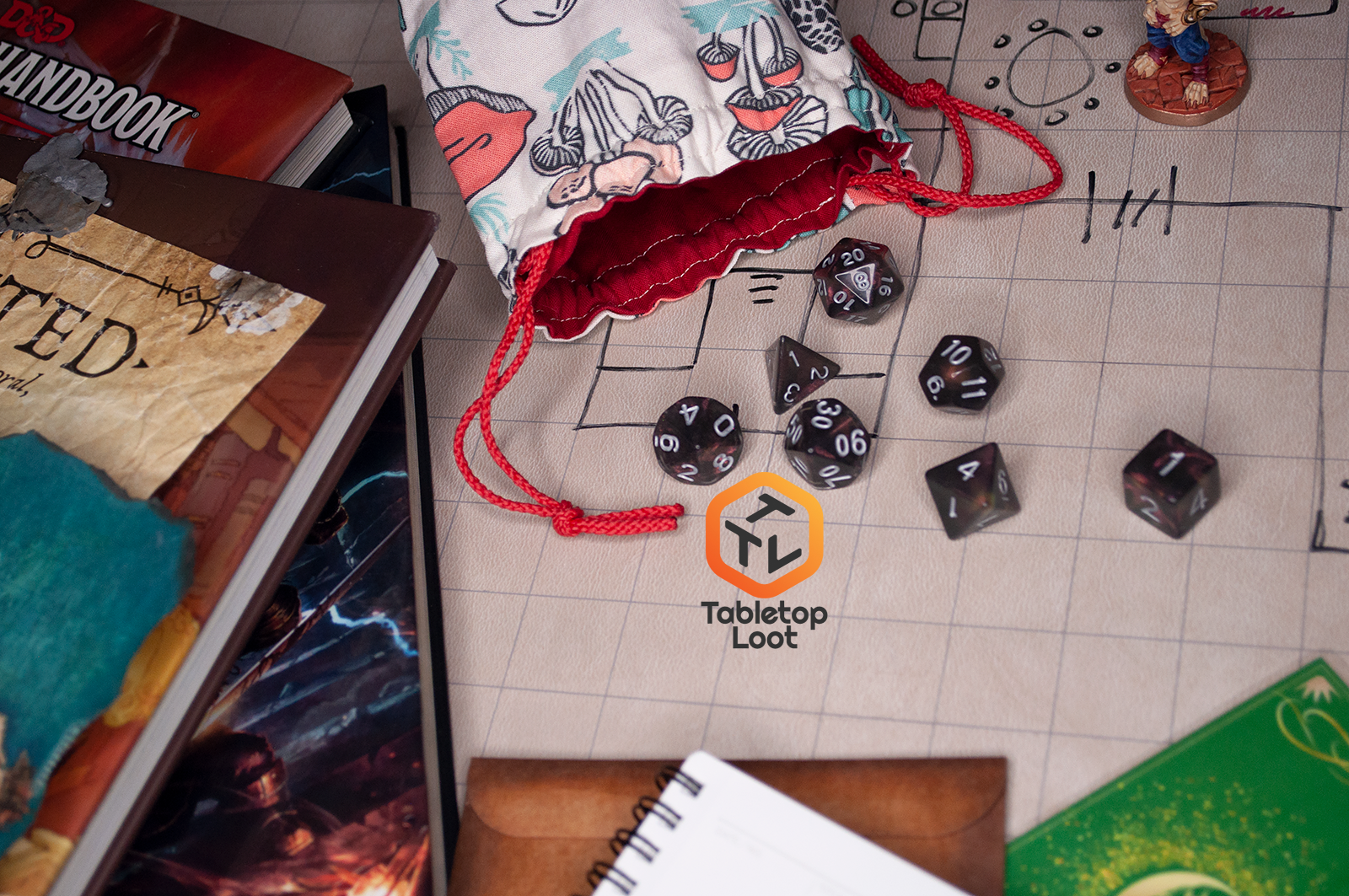 The Dark Star 7 piece dice set from Tabletop Loot with glittering swirls of pink, green, gold, and blue, inked in silver, spills across a gaming table.