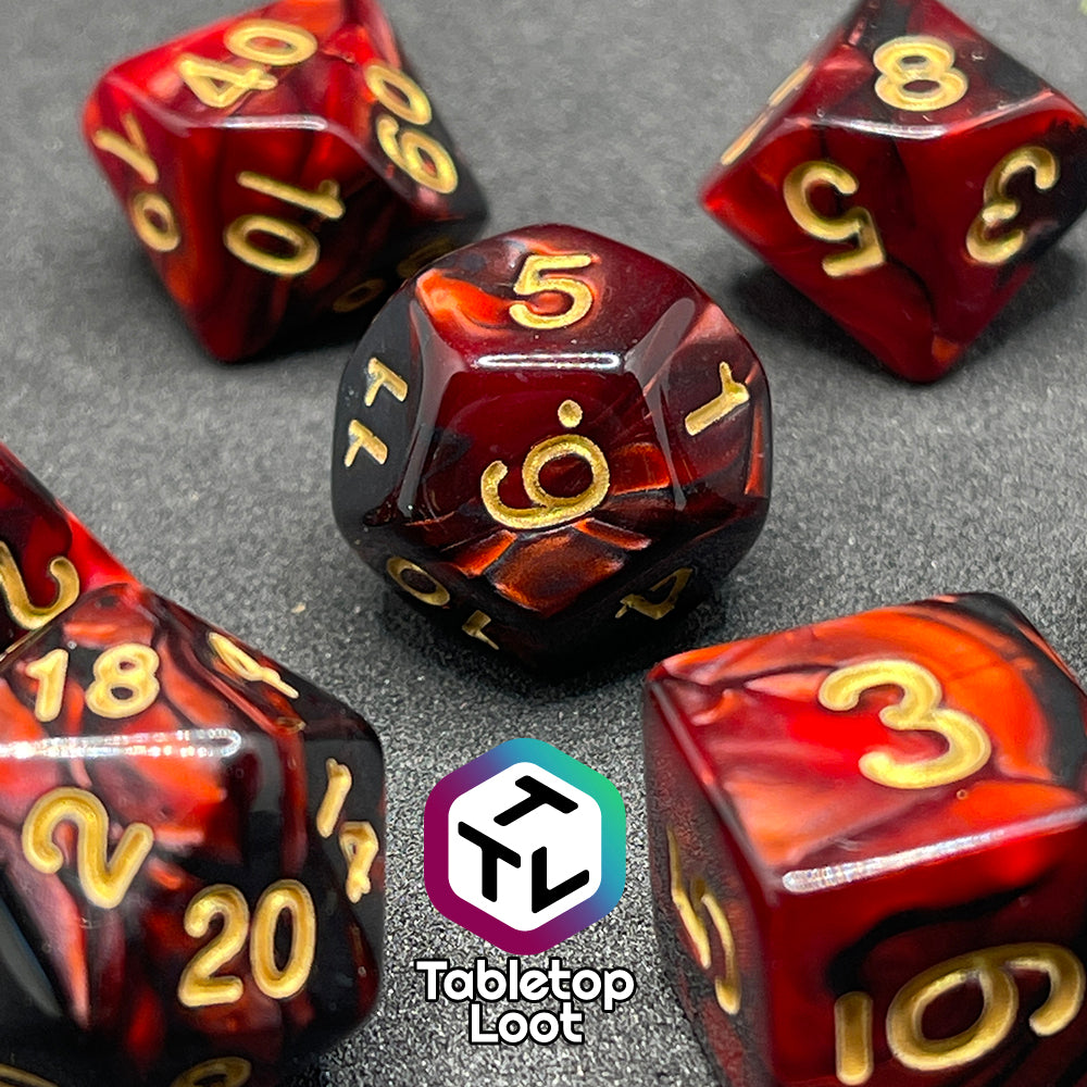 A close up of the Demon Stones 7 piece dice set from Tabletop Loot with swirls of pearlescent red and black and golden numbering.