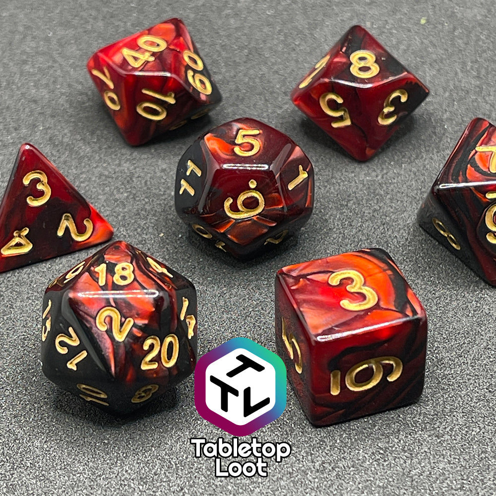 The Demon Stones 7 piece dice set from Tabletop Loot with swirls of pearlescent red and black and golden numbering.