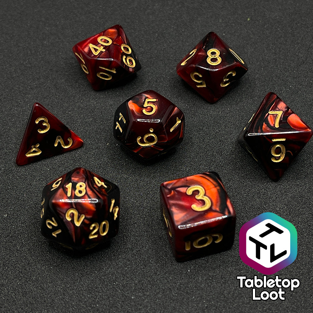The Demon Stones 7 piece dice set from Tabletop Loot with swirls of pearlescent red and black and golden numbering.